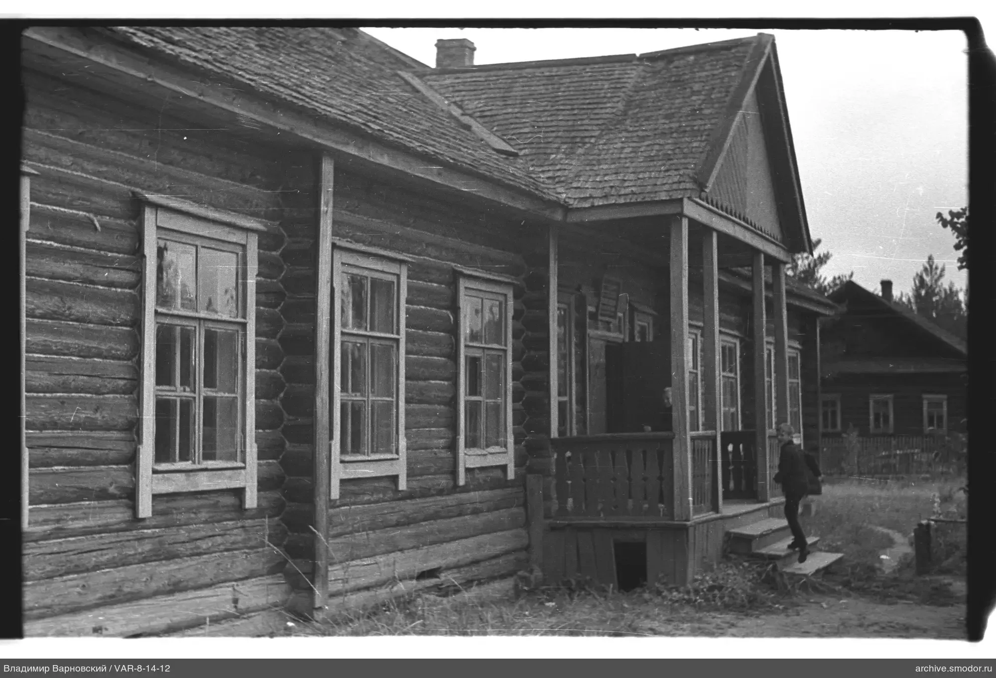Holzhaus mit Veranda und Personen