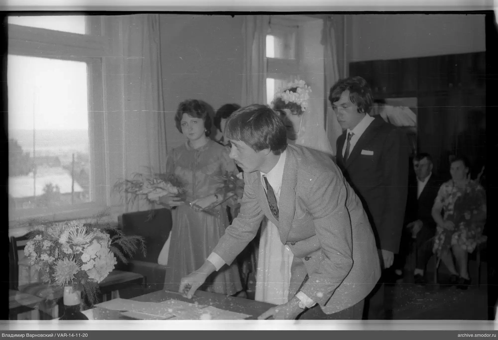 Mann mit Papieren und Hochzeitspaar