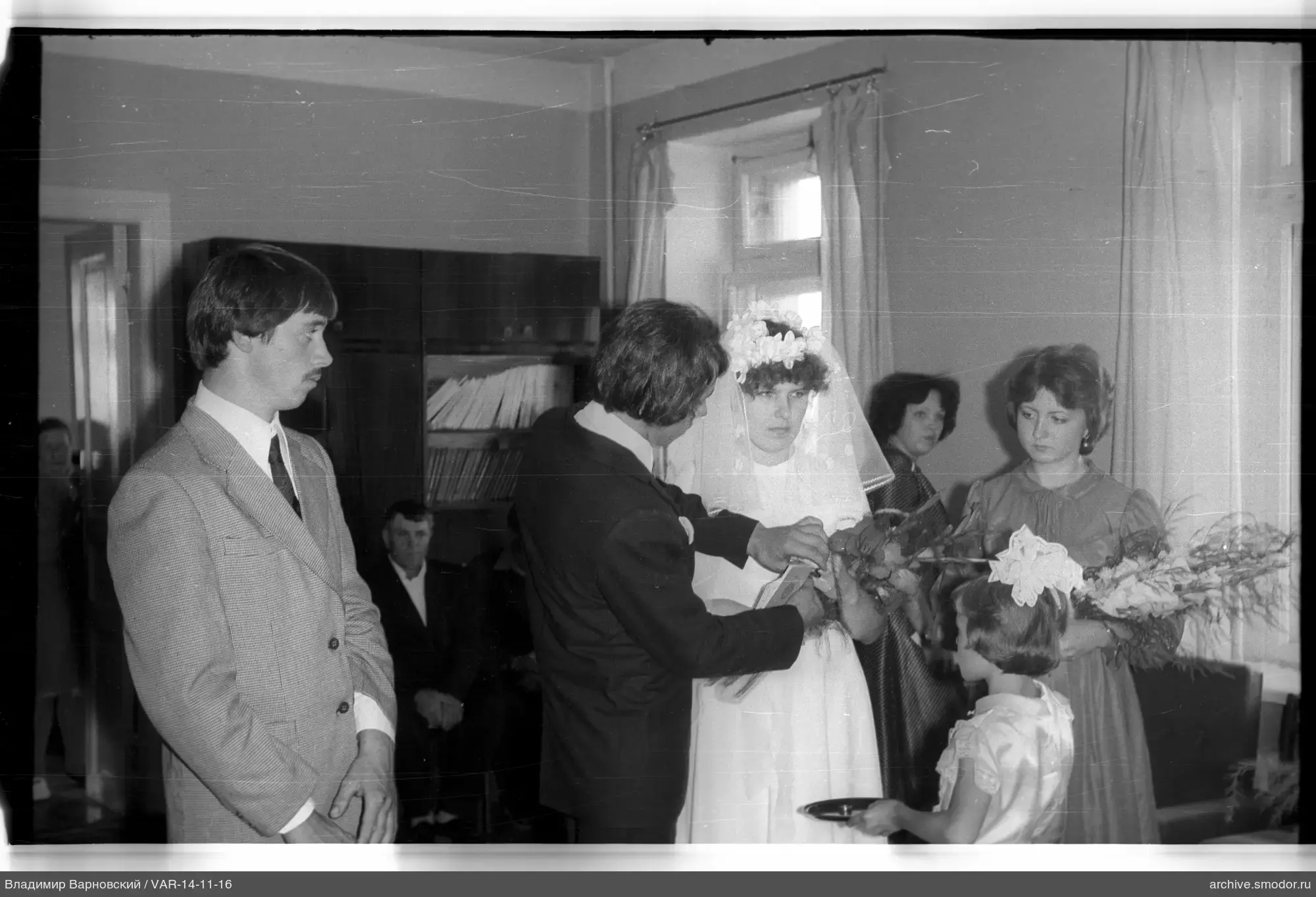 Man placing something in bride's hand
