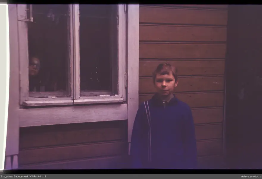 Children by the wooden house wall