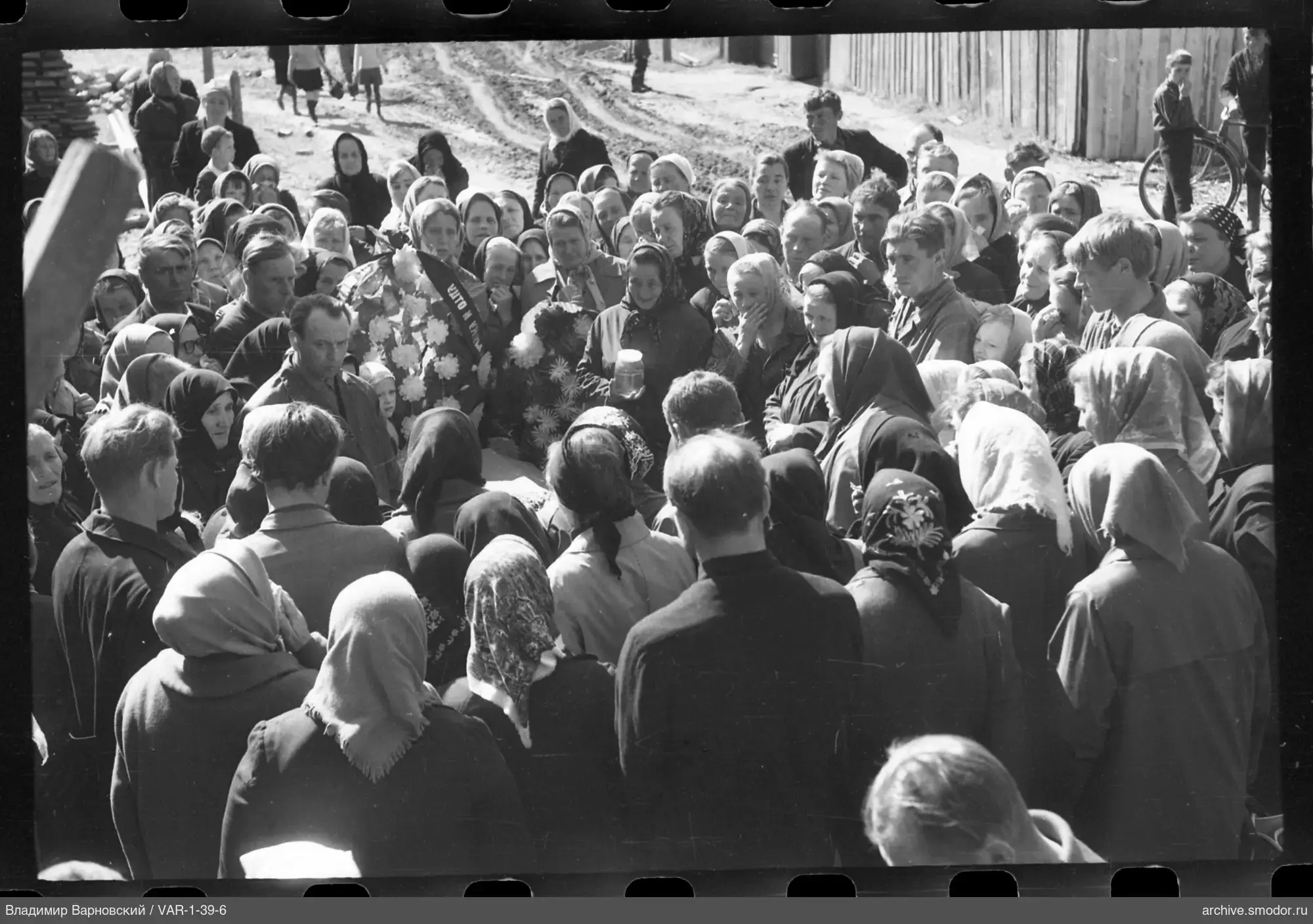 Gruppe mit Kranz und Blumen auf der Straße