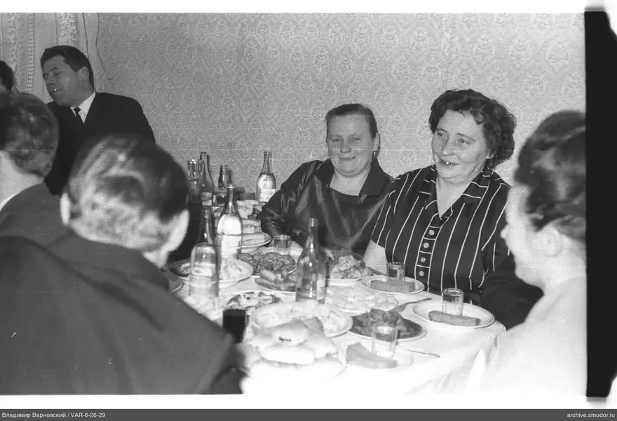 People sitting at a table with food and drinks