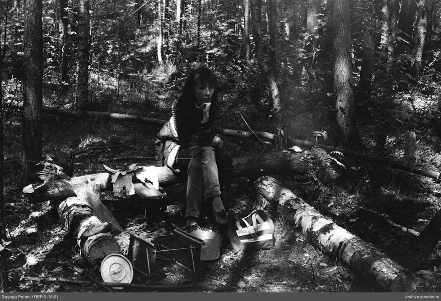 Frau auf einem Baumstamm im Wald