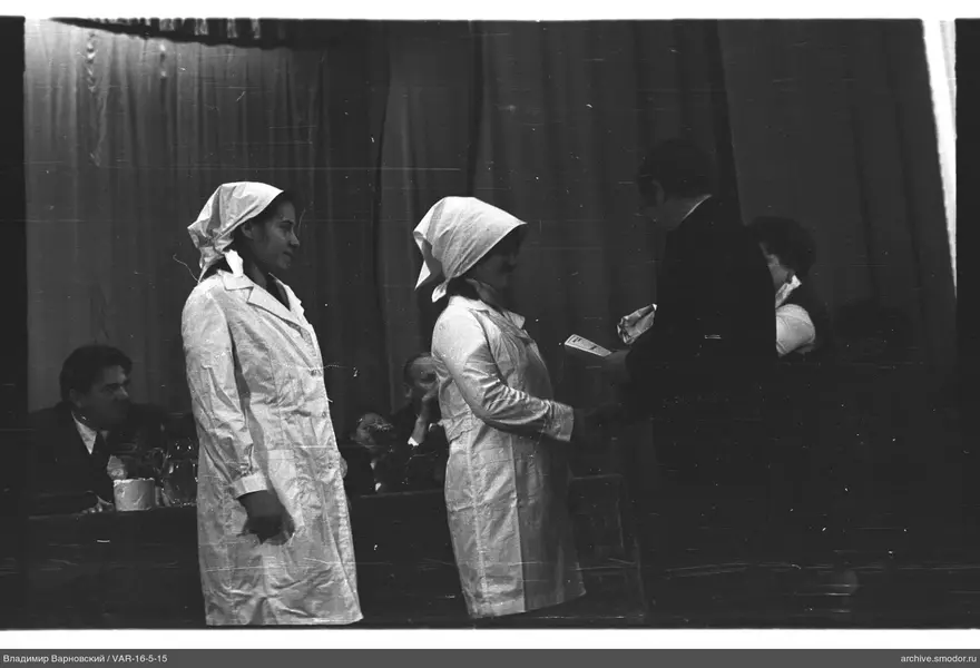 Women in white coats receiving document