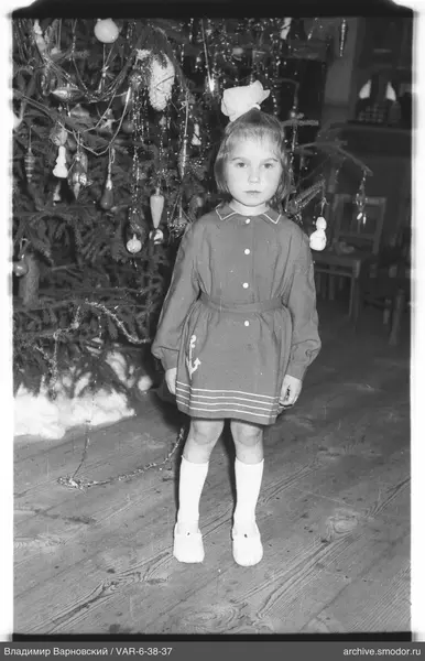 Mädchen vor geschmücktem Weihnachtsbaum