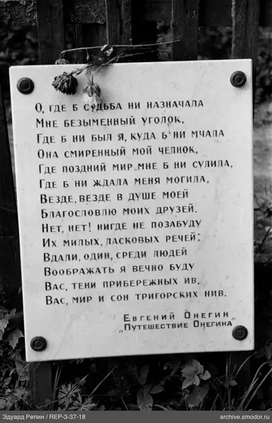 Gedenktafel mit Gedicht und getrockneten Blumen