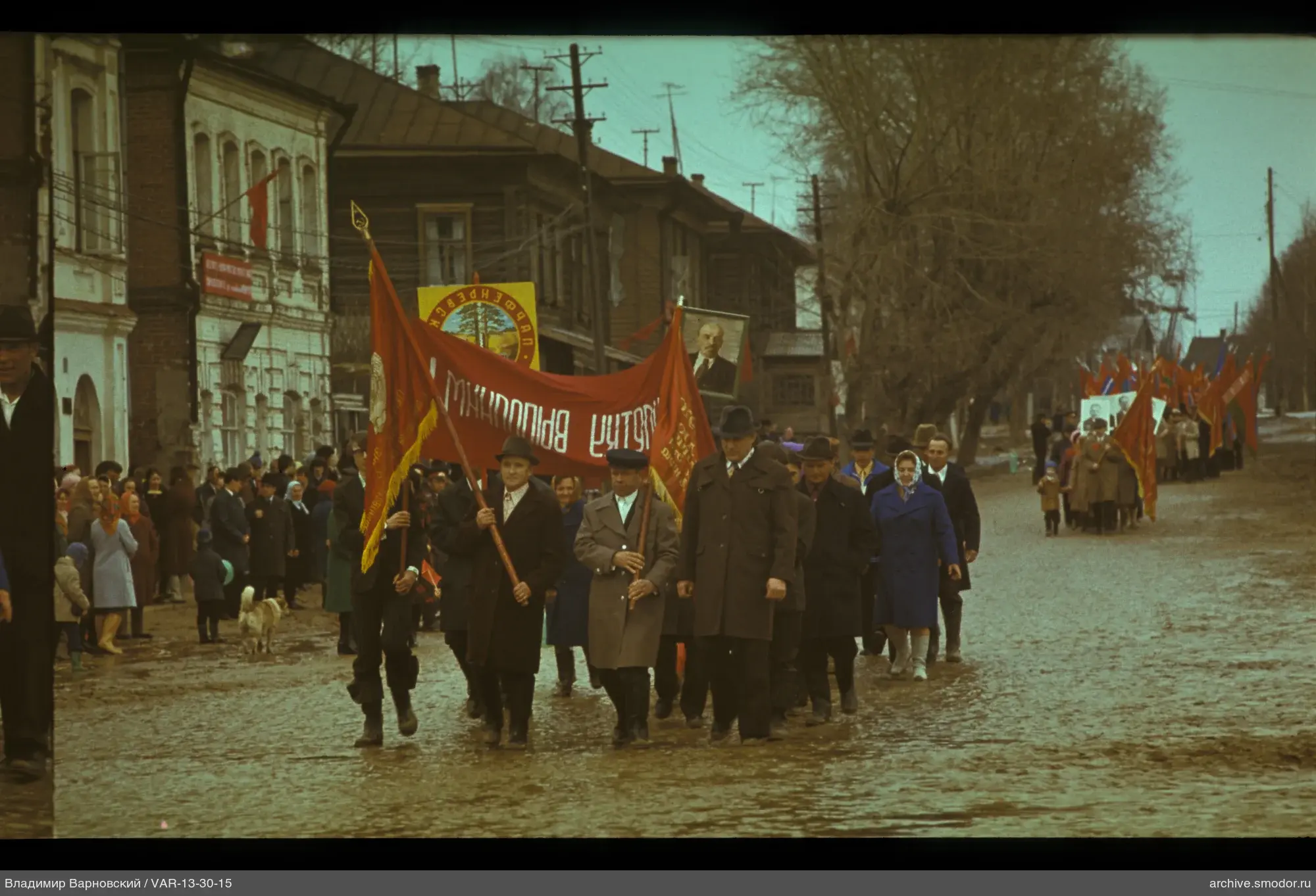 Группа людей с красными знаменами и портретом Ленина