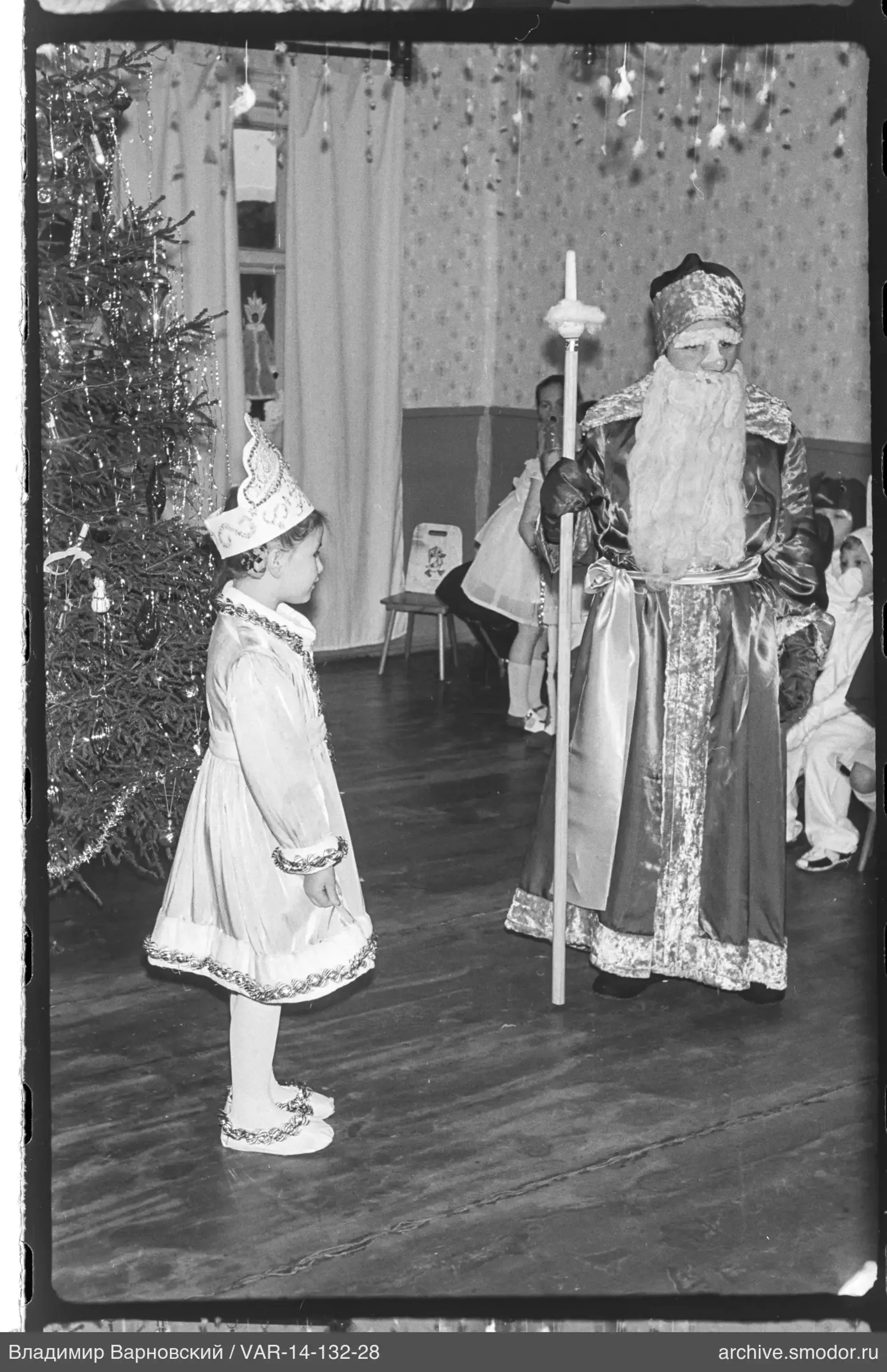 People in costumes near decorated Christmas tree