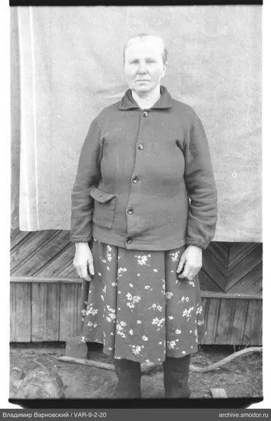 Frau in dunkler Jacke und Blumenrock