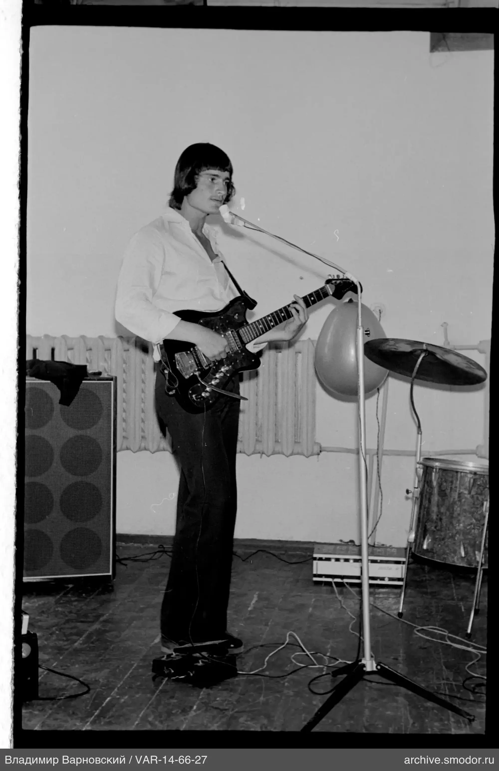 Junger Mann mit Gitarre und Mikrofon