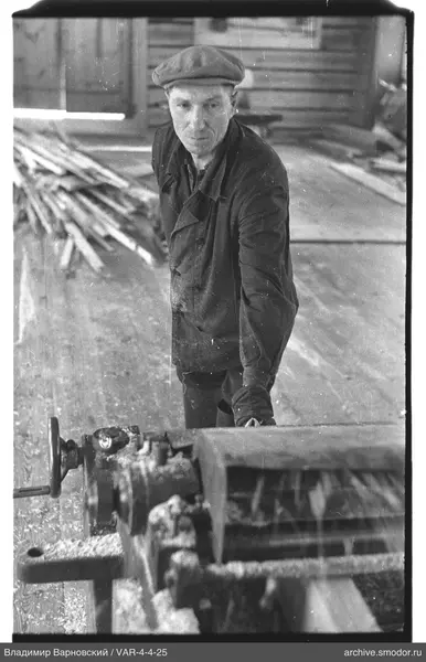 Man at a machine with wooden boards