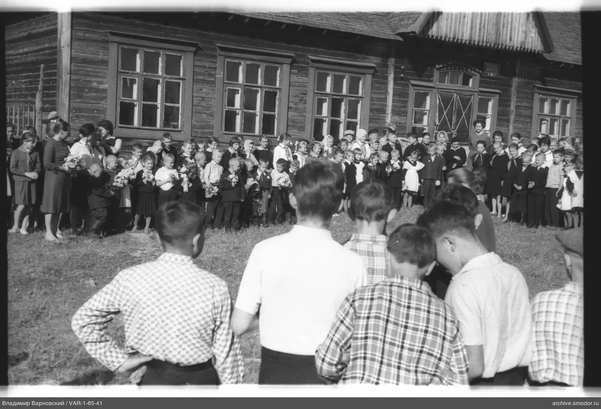 Gruppe von Kindern und Erwachsenen vor der Schule