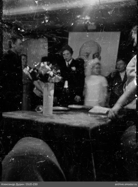 Люди за столом с цветами и книгой