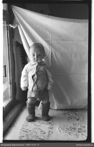 Kind im Overall am Fenster