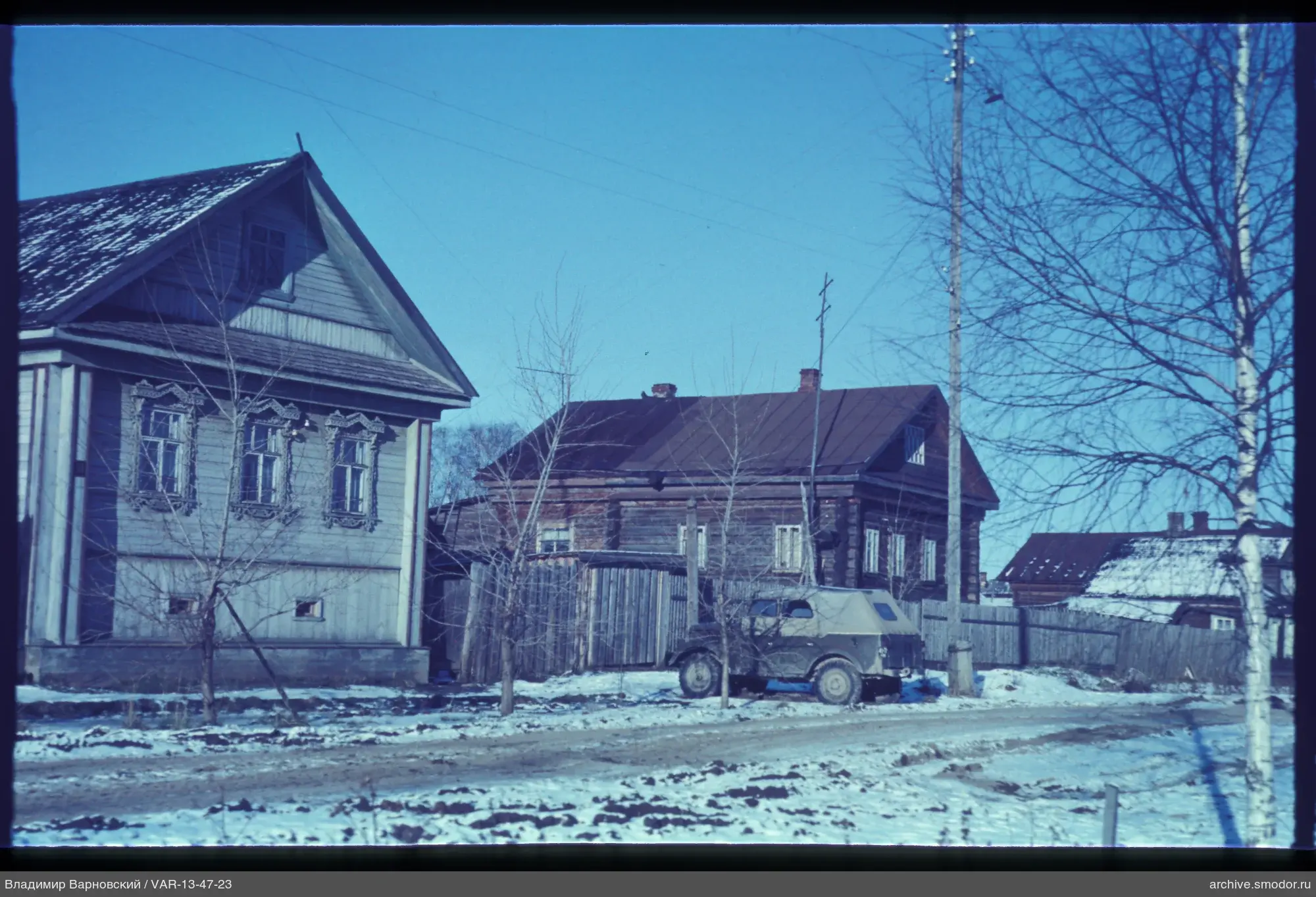 Holzhäuser und schneebedeckte Straße
