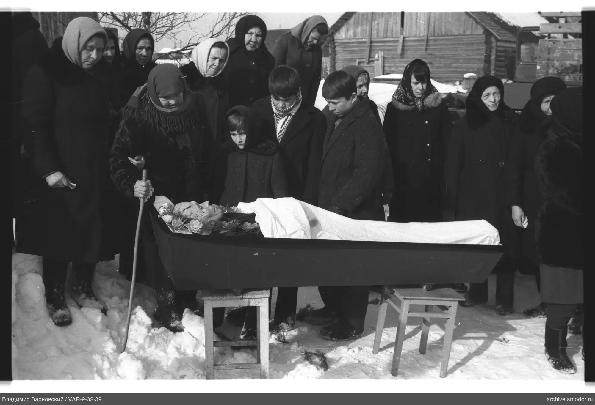 Group photo around an open coffin
