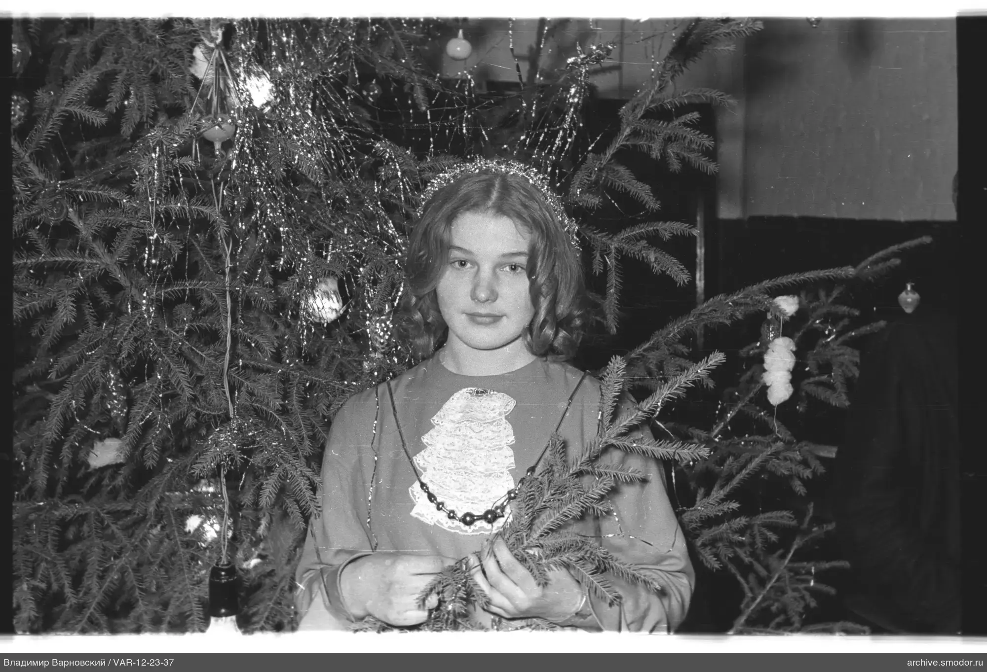 Porträt eines Mädchens vor geschmücktem Weihnachtsbaum