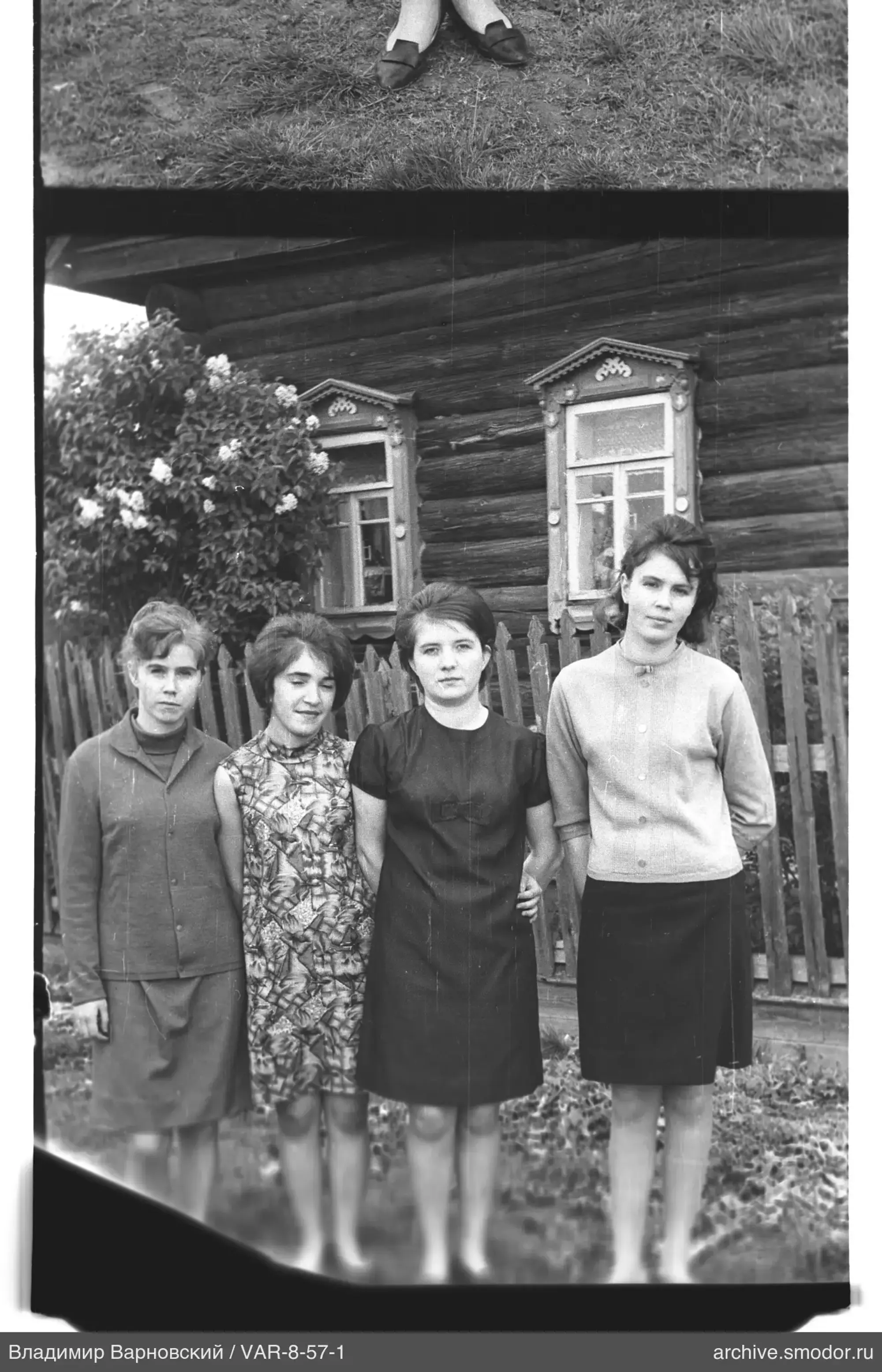 Gruppenporträt von Frauen vor Holzhaus