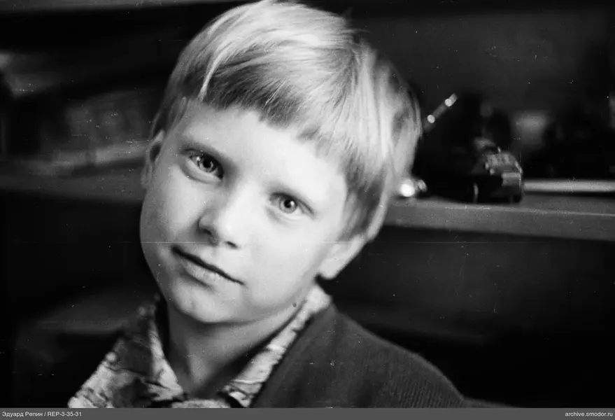 Porträt eines Jungen mit Spielzeugen im Regal