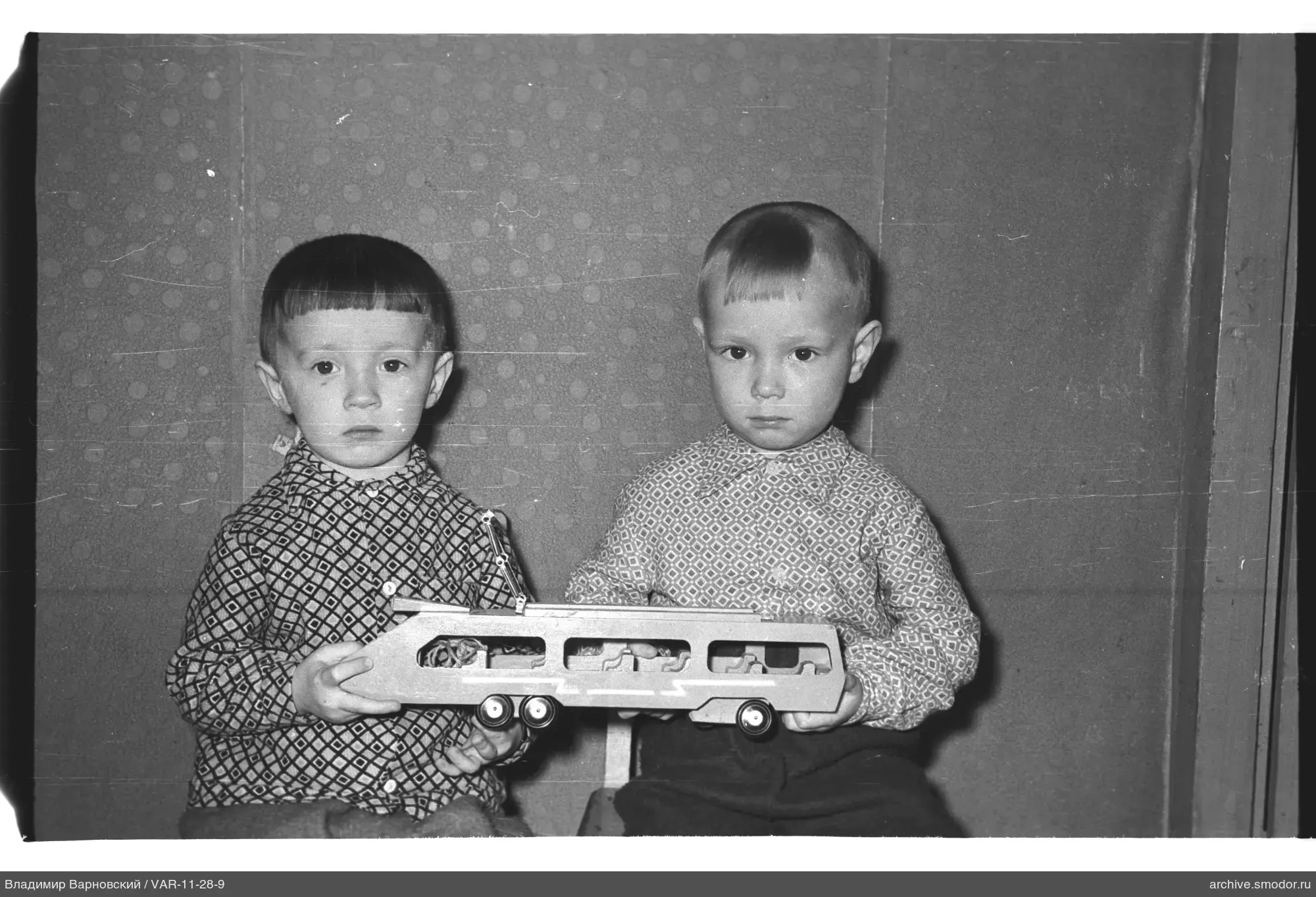 Two boys with wooden toy car