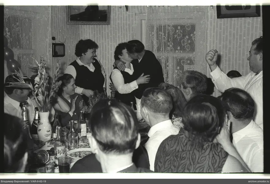 People at a table with central kiss