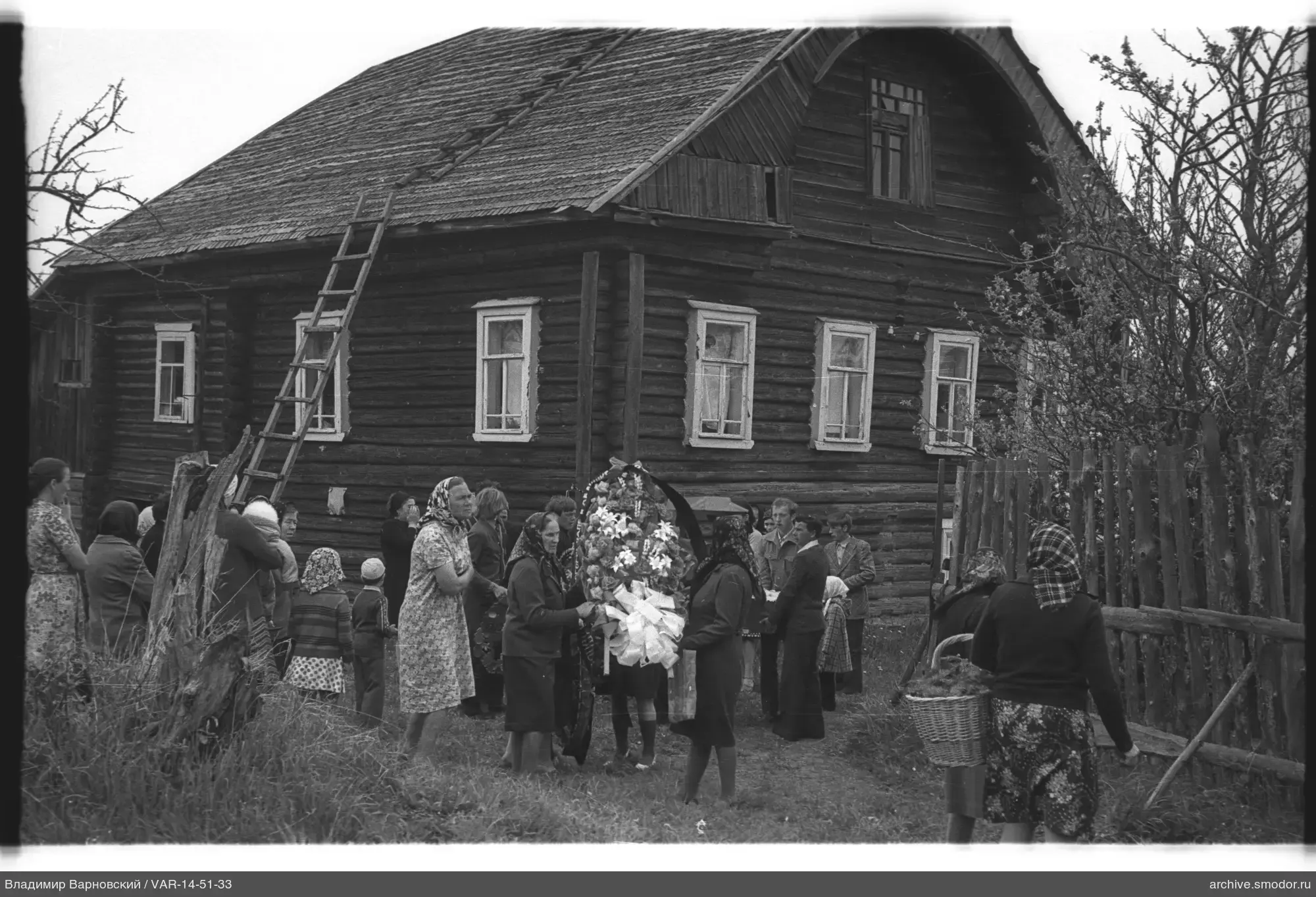 Группа людей у деревянного дома