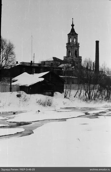 Landschaft mit Holzgebäude und Glockenturm