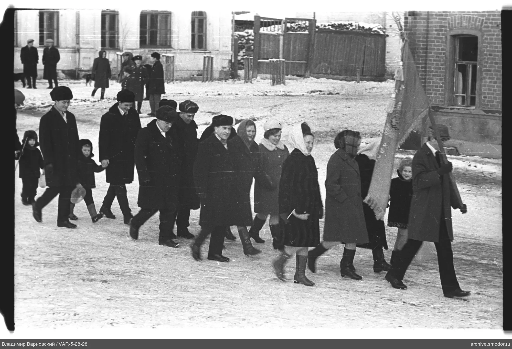 Gruppe mit rotem Banner auf verschneiter Straße