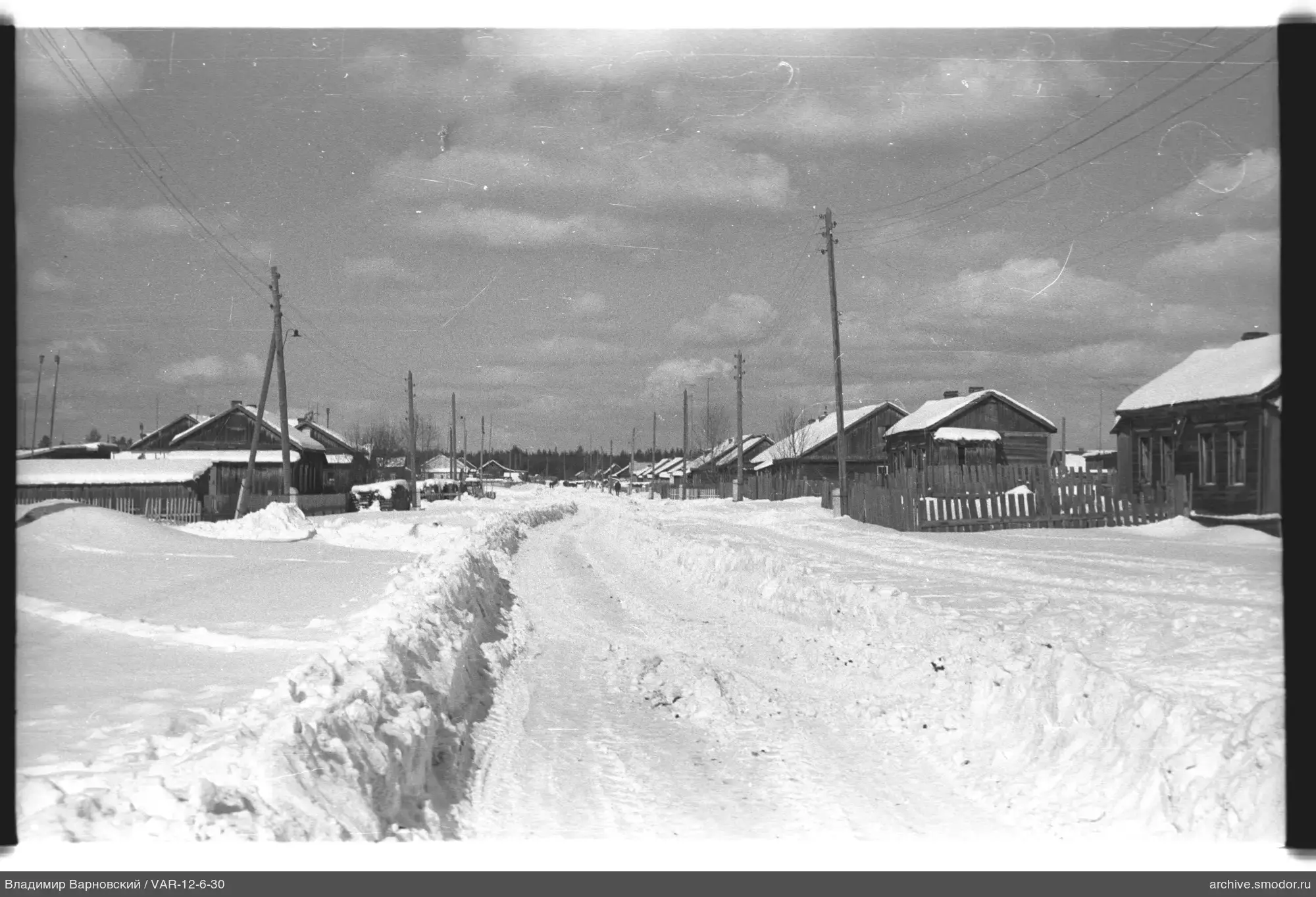 Schneebedeckte Straße mit Holzhäusern