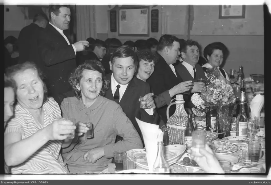 Group of people at a table with dishes and flowers