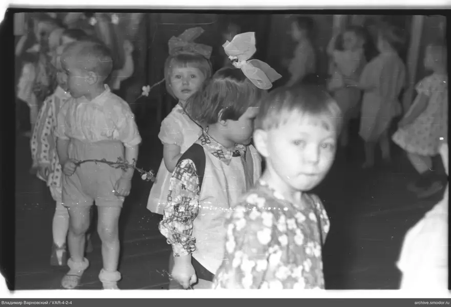 Gruppenaufnahme von Kindern mit Schleifen und Zweig