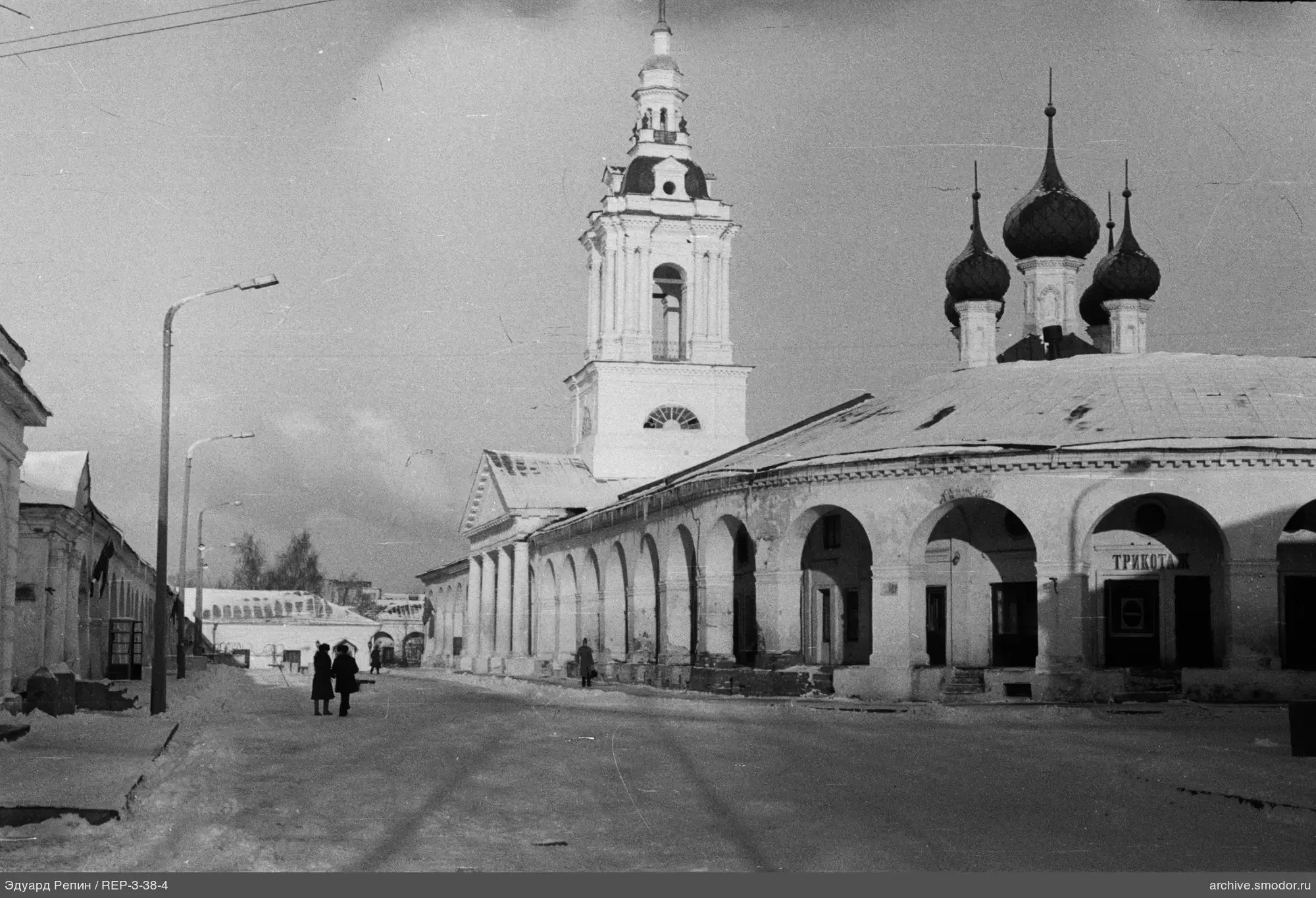 Здание с арочными проходами и вывеской "ТРИКОТАЖ"