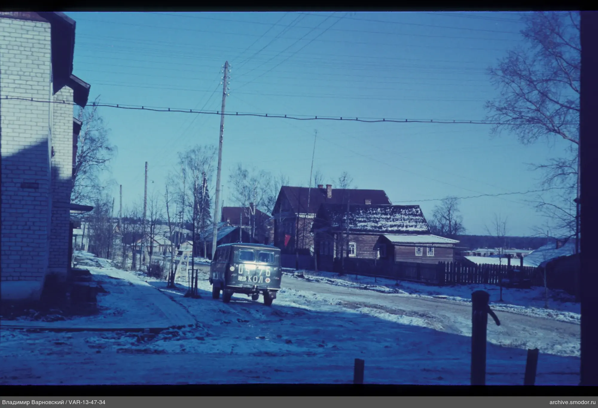 Snowy street scene with houses and minibus
