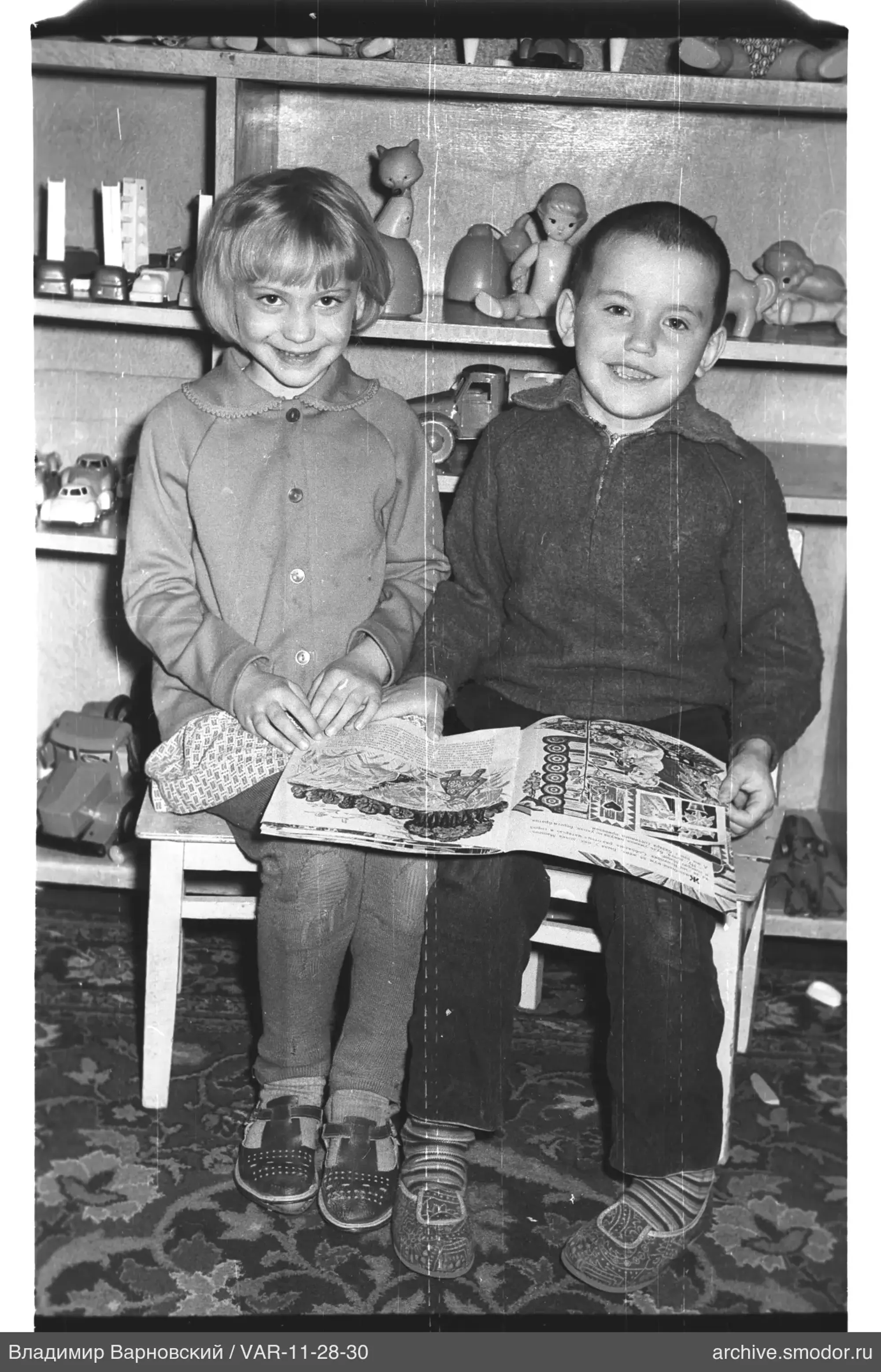 Kinder mit Buch und Spielzeug