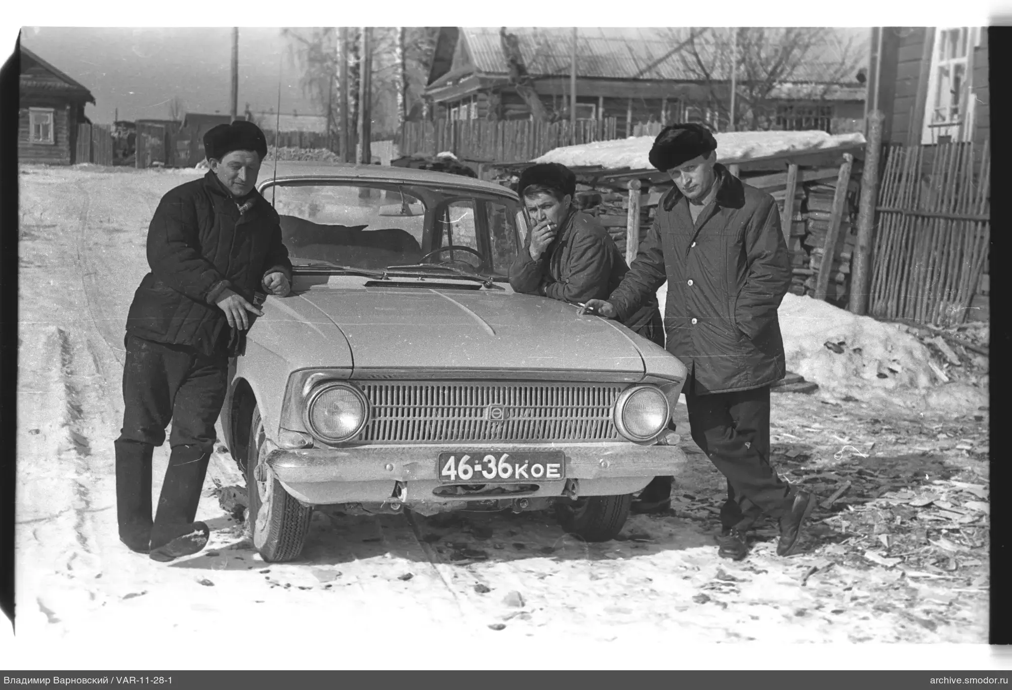 Gruppe von Männern am Auto im Schnee