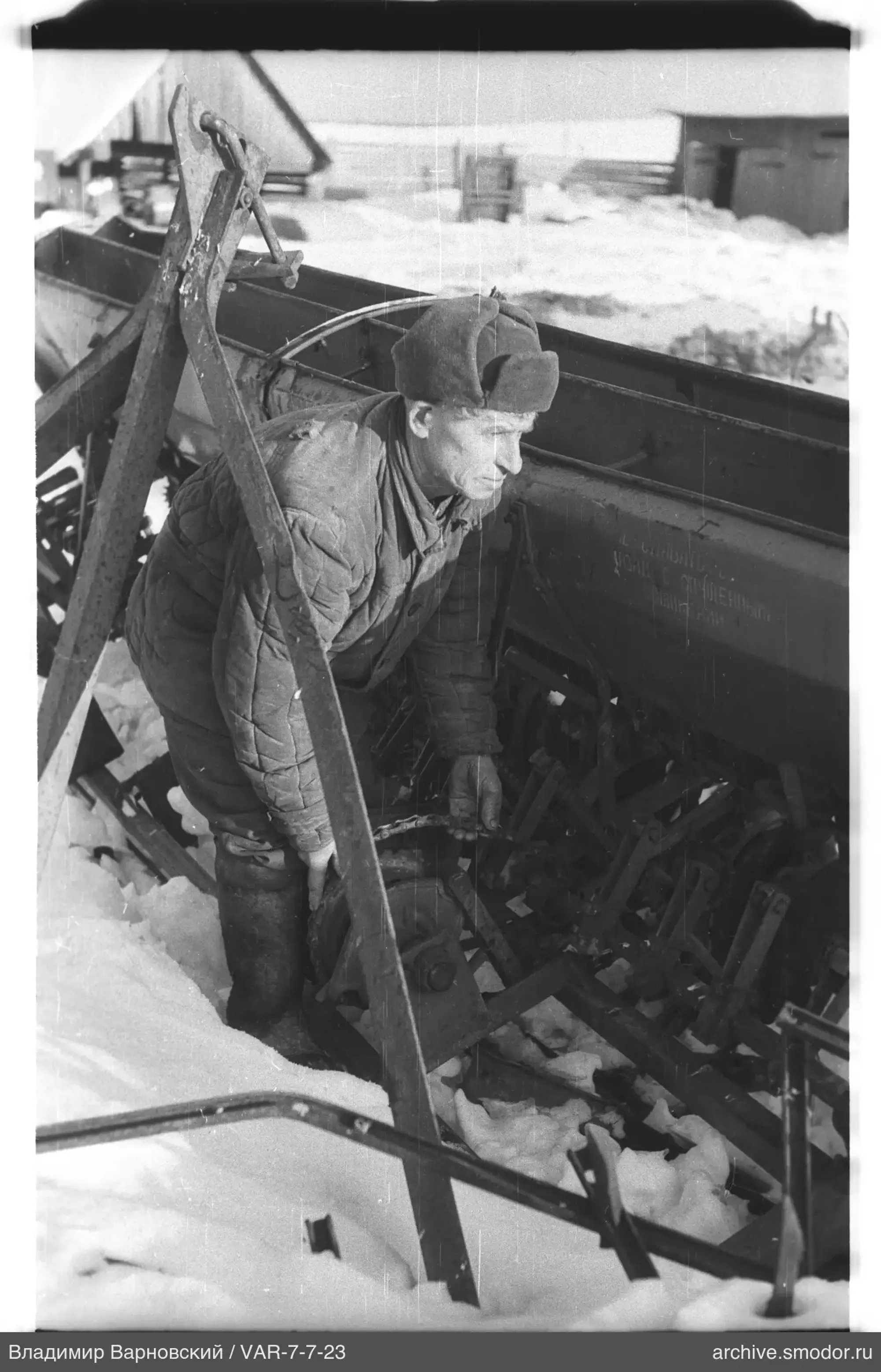 Mann mit landwirtschaftlicher Maschine im Schnee