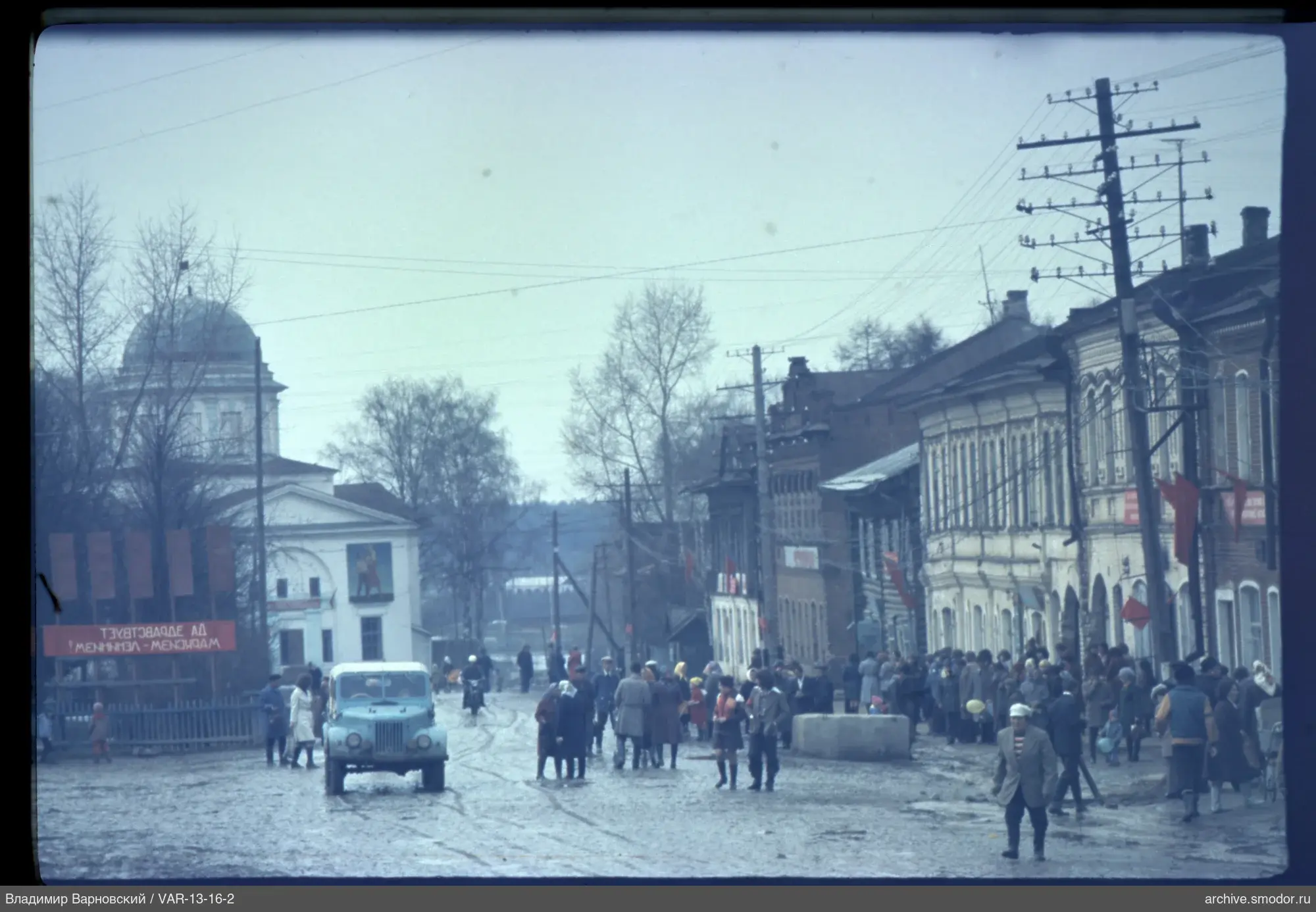 Straße mit fahrenden Autos und Menschen