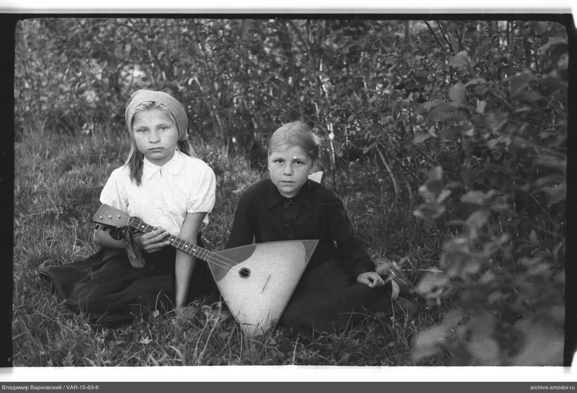 Zwei Mädchen mit Balalaika im Gras