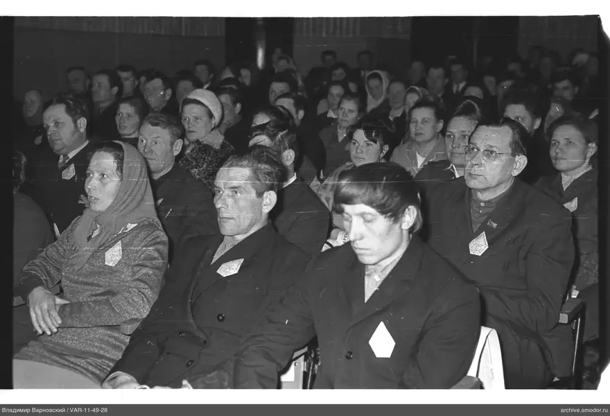 Gruppe von Menschen im Saal mit Abzeichen auf Kleidung