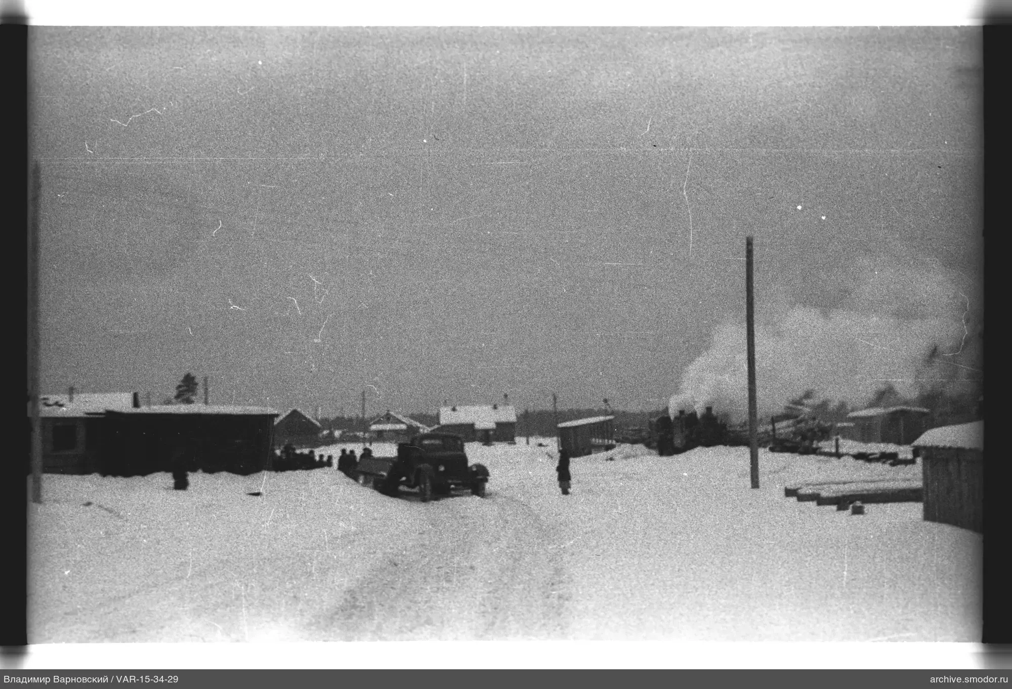 Verschneite Straße mit Häusern und Dampflokomotive