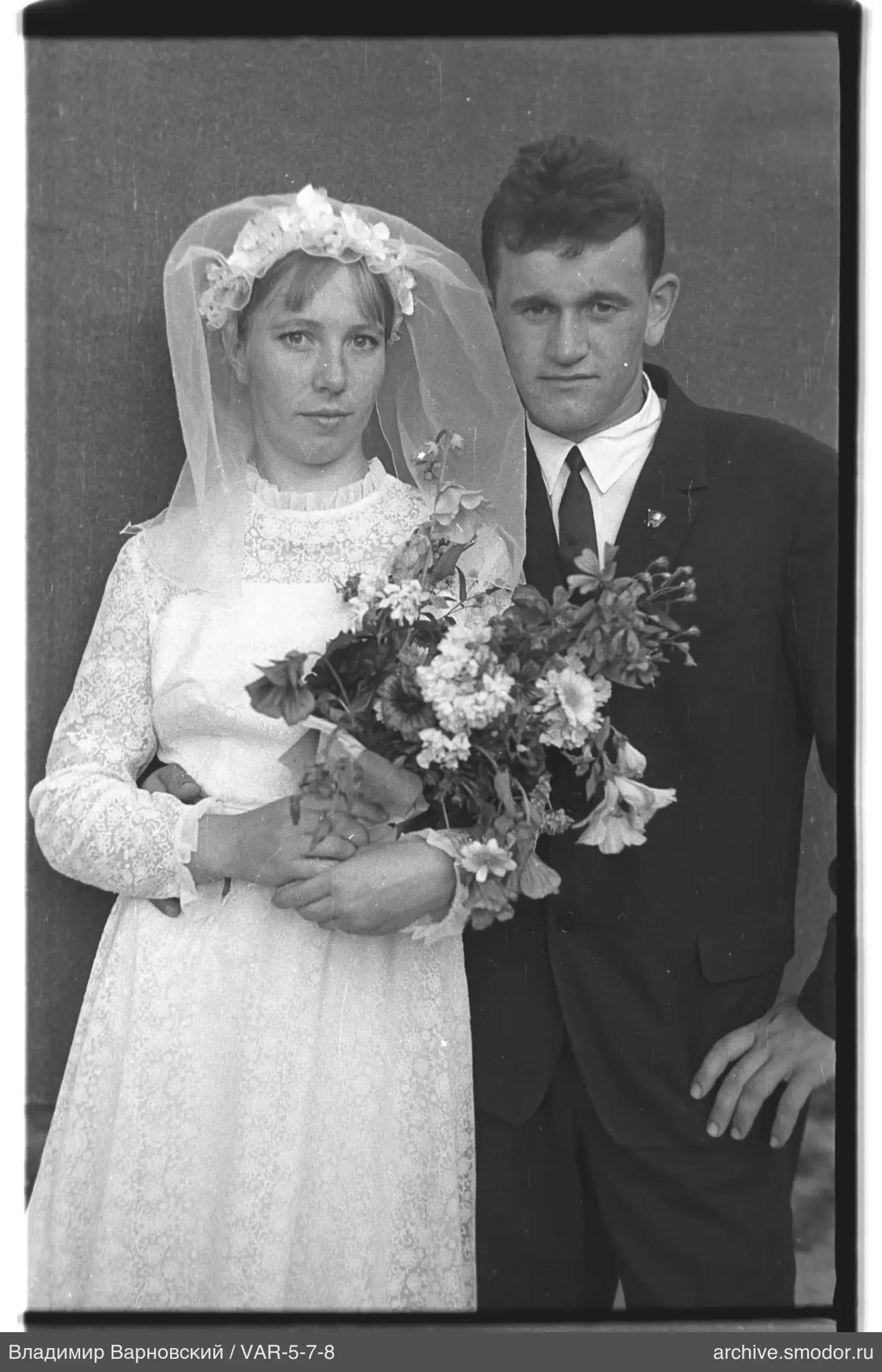 Gruppe mit Frau im Hochzeitskleid und Blumenkranz
