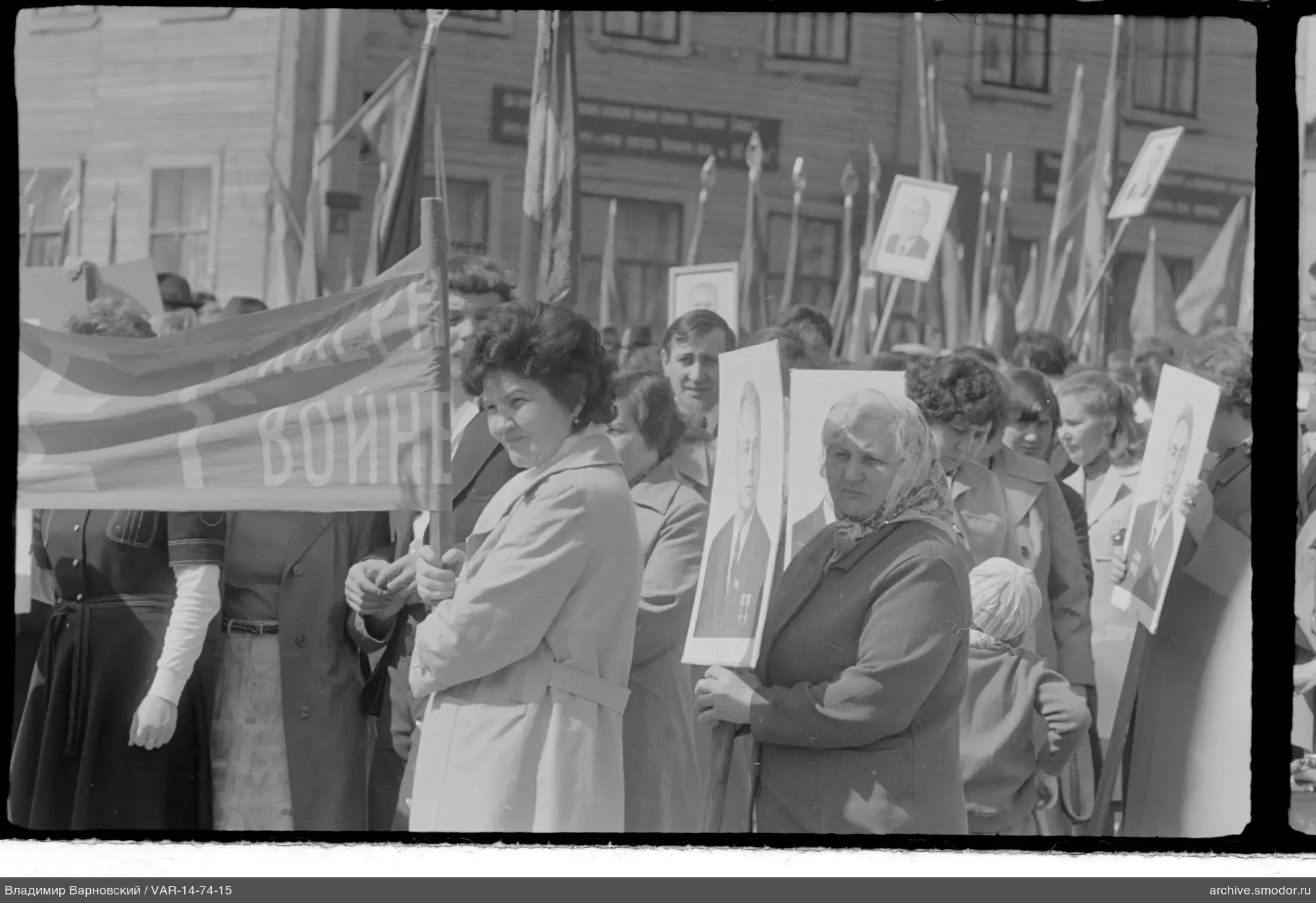 Gruppe von Menschen mit Porträts und Fahnen auf der Straße