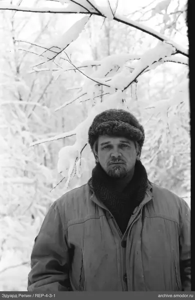 Портрет мужчины на фоне снежных деревьев