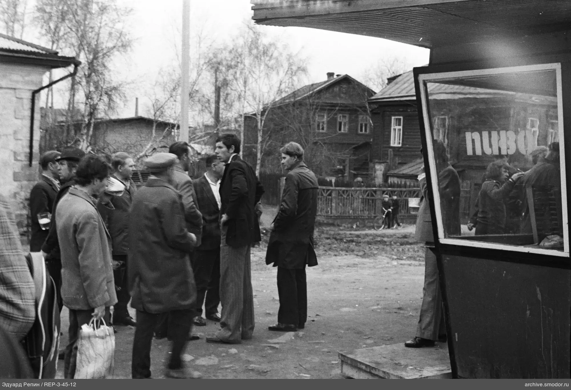 Gruppe von Männern bei einem Gebäude mit Bude