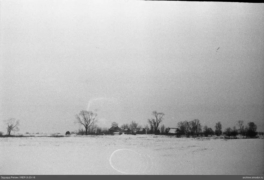 Landschaft mit Schneefeld und Gebäuden