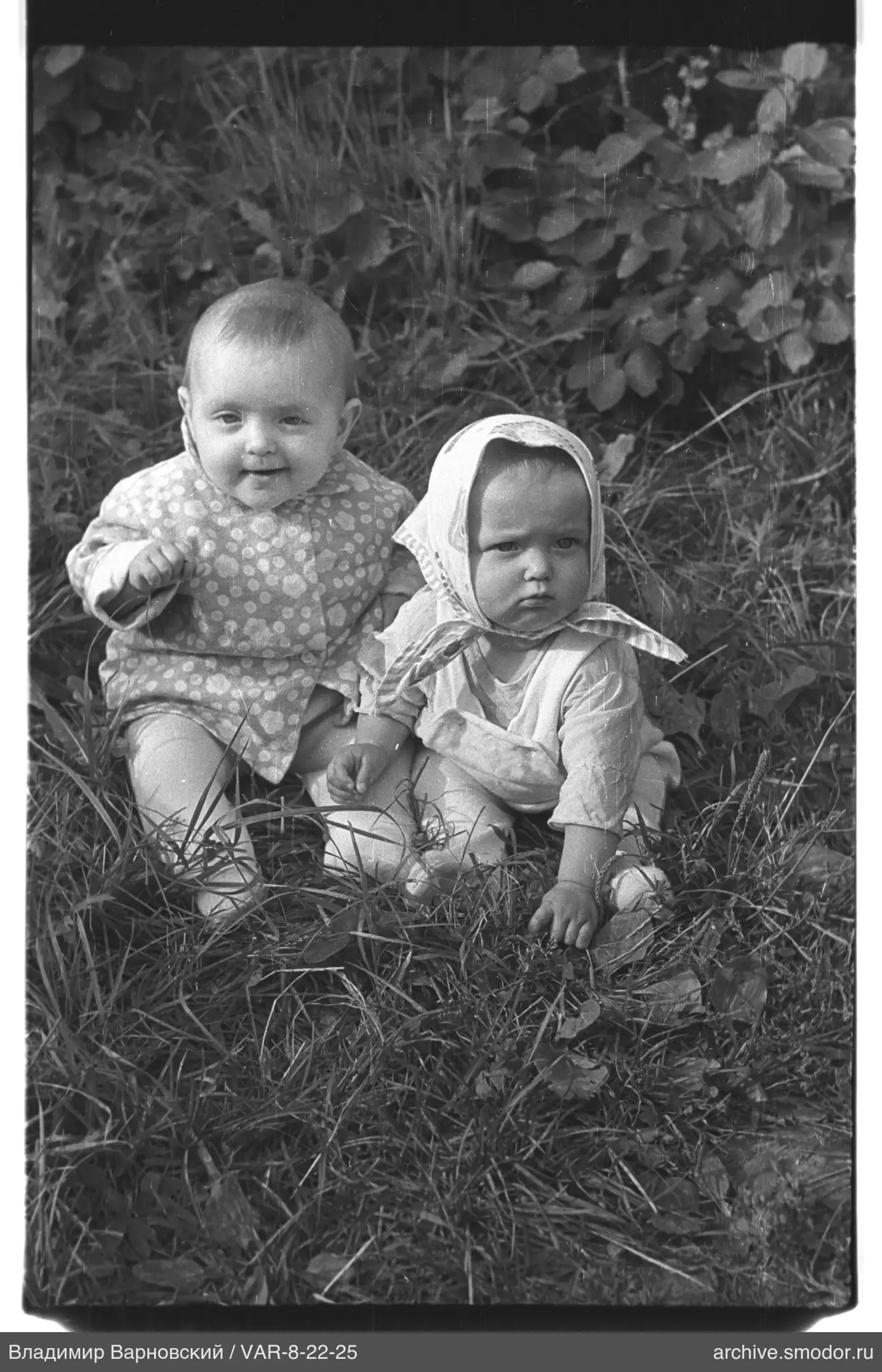 Two children sitting on the grass