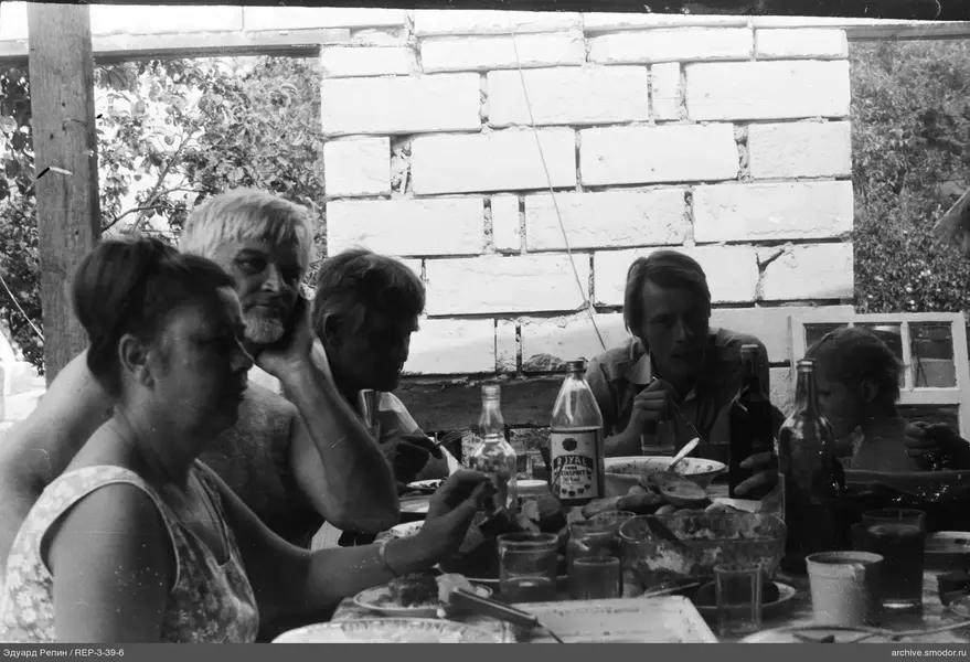 Gruppe am Tisch mit Geschirr und Flaschen