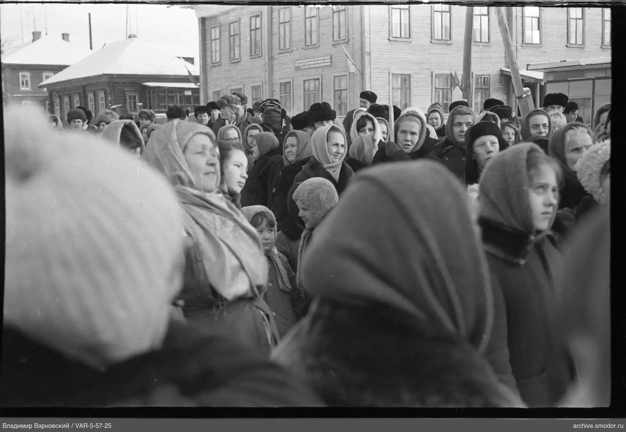 Group of people on the street in front of wooden buildings