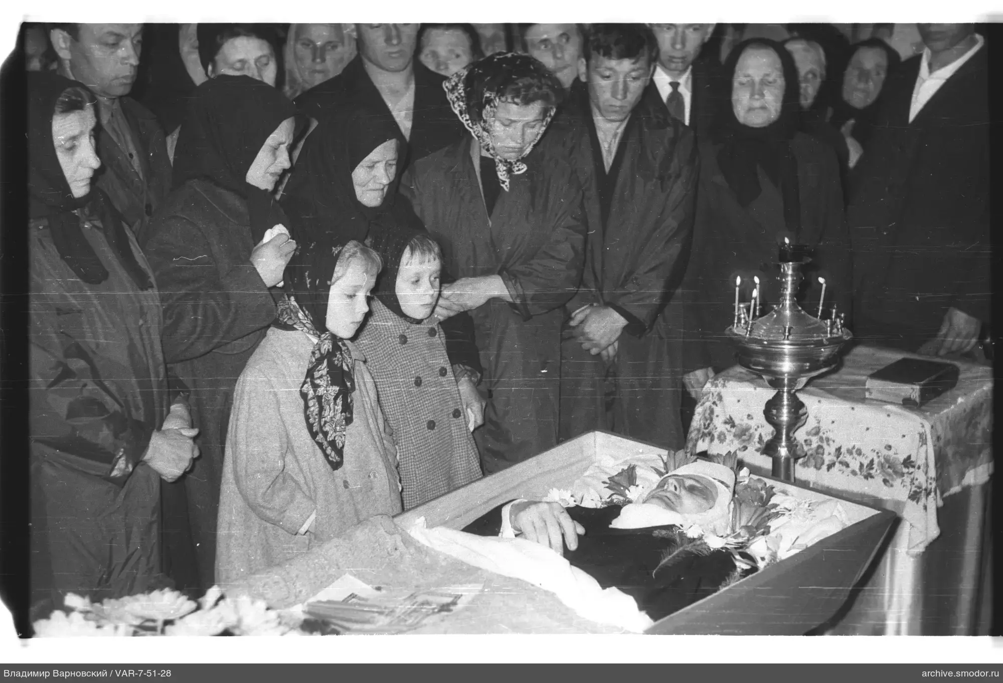 Group of people around an open coffin