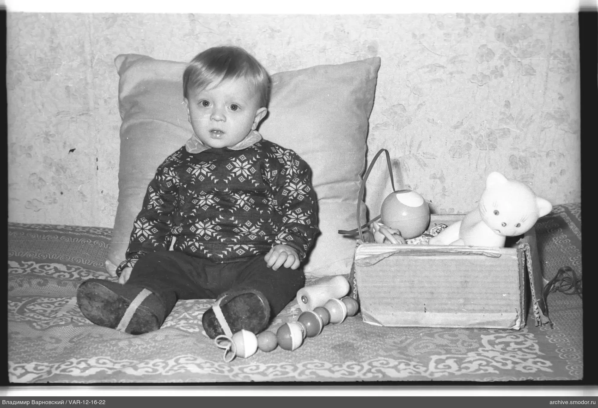 Child sitting on sofa with toys